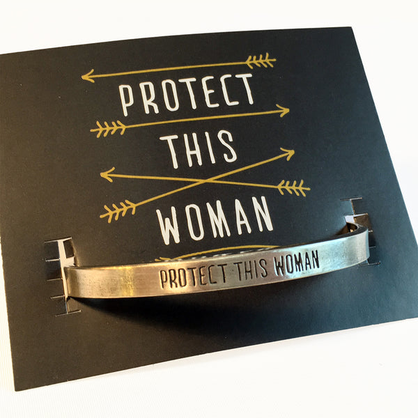 Protect This Woman Pewter adjustable cuff bracelet with backer card.  "Protect This Woman" displayed on face of bracelet.